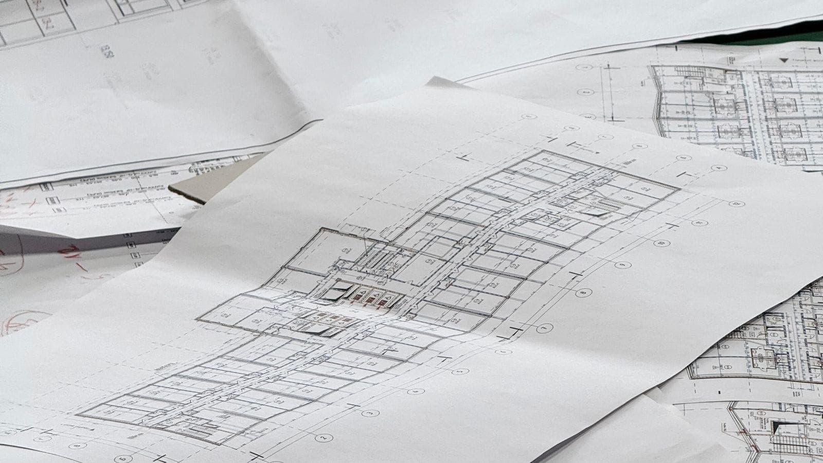 Detailed architectural blueprints and construction drawings spread out on a desk