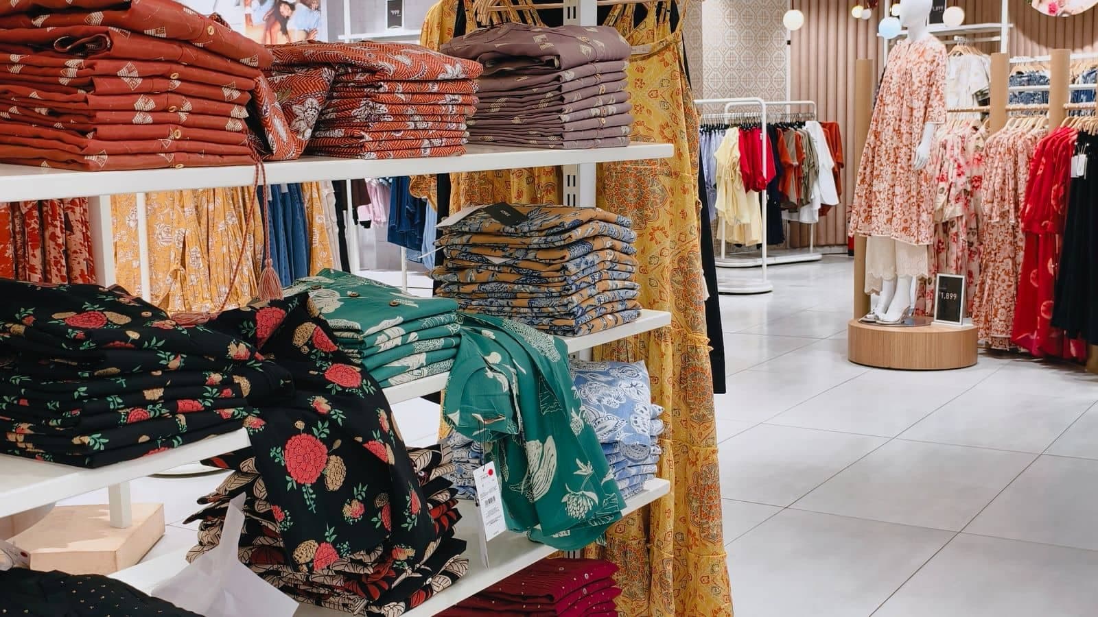 Bright, spacious modern fashion store interior with colorful clothing displays