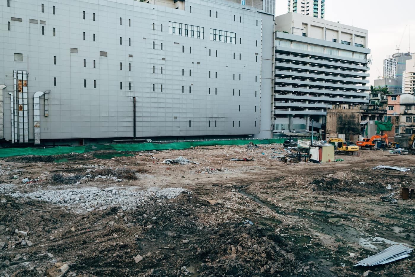 A commercial construction site with a partially built structure among modern city buildings