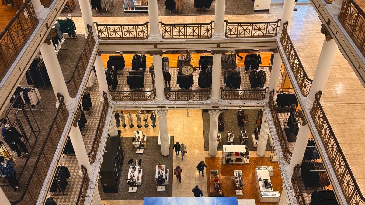 Overhead view of a multi-floor department store interior with clothing displays and balustrades