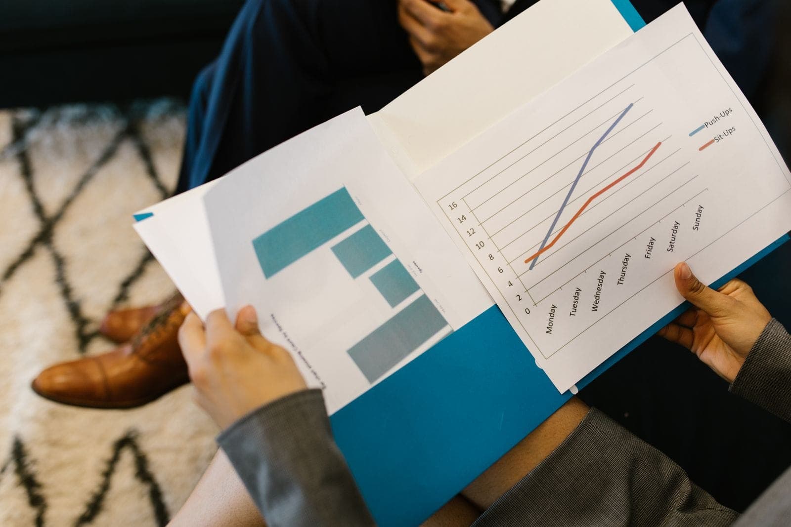 Printed business reports with bar and line charts on a table during a meeting