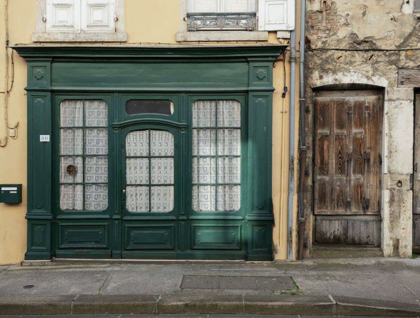 Elegant dark green painted retail storefront with a large glass display window and a tasteful entrance door
